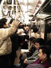 On board a Tokyo commuter train. Photo (c) 1999 Adrian Williams