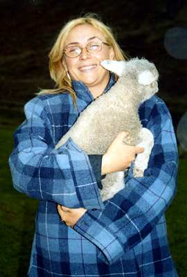 Sonja on a New Zealand farm, holding a lamb. Photo © 2003 Hans Zulauf