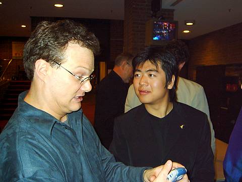 A better pianist than photographer: Lars Vogt pulls a face as he looks at photos he's taken on his cell phone of himself and Lang Lang. Photo © 2004 Phil Crebbin