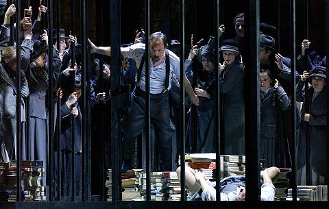 John Uhlenhopp as Count Heinrich caged (it's a metaphor, stupid!) resisting all that Heidi Brunner's Eva wishes to bestow while the townsfolk grab an eyeful. Photo © Volksoper Wien/Dimo Dimov