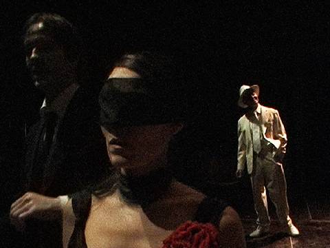 'Hoy es Domingo'. From the closing scene of Part Two. Maria is temporarily blindfolded as time is stolen from her eyes. Guido Paevatalu, as 'A Voice on That Sunday', looks on. Photo © Casper Sejersen