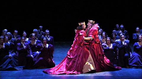 Béatrice Uria-Monzon (Queen Gertrude) and Alain Vernhes (King Claudius) with the Elsinorians in Act 1 of Hamlet. DVD screenshot © Fundacio del Gran Teatre del Liceu