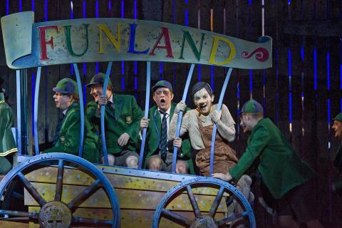The Chorus of Opera North, Allan Clayton (Lampwick, centre) and Victoria Simmonds (Pinocchio). Photo © 2007 Clive Barda