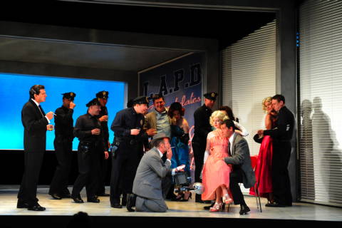 Fran Garcia as Marullo, seated, and chorus in Act I of Grange Park Opera's 'Rigoletto' at Nevill Holt. Photo © 2009 Alastair Muir